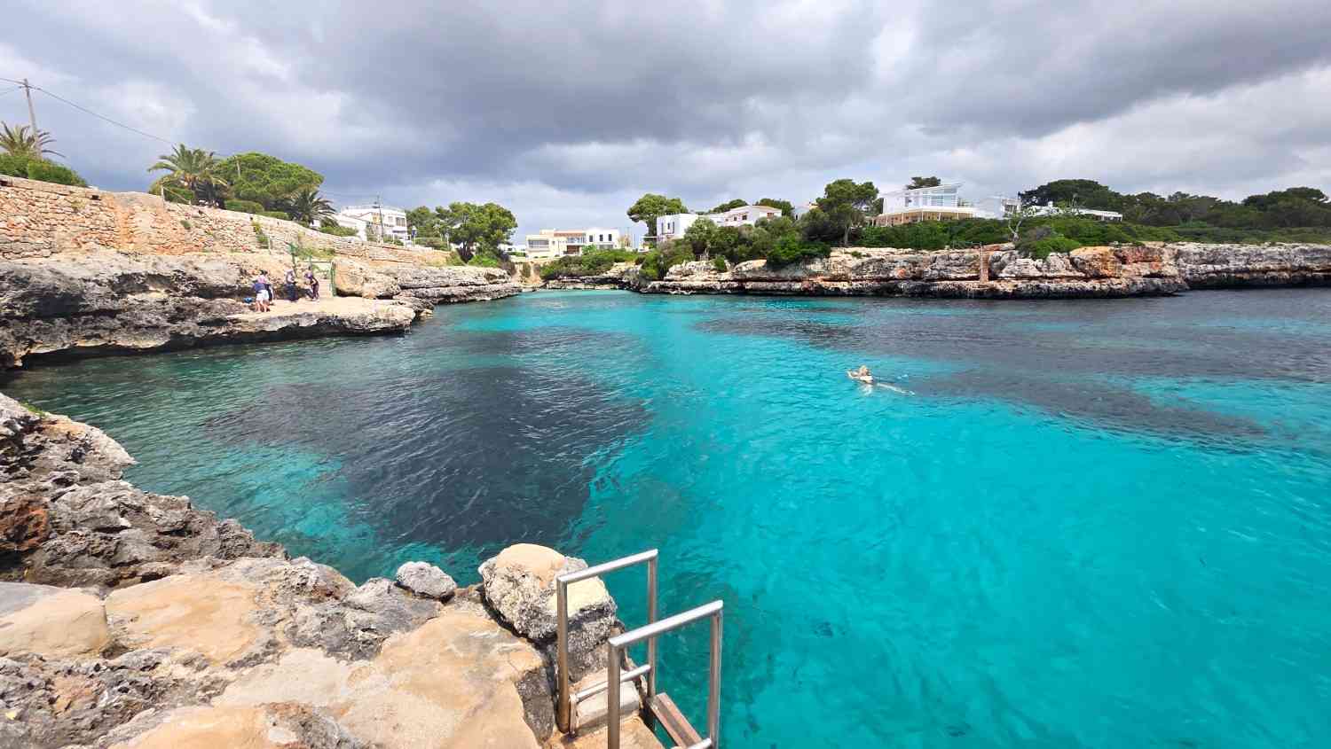 Turquoise water and rocky shoreline at Sa Farola Beach